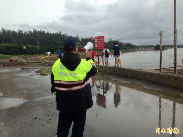 桃園地景藝術節「蟹」絕訪客，遊客見沿海風雨小闖進、員警忙勸導。（記者李容萍攝）