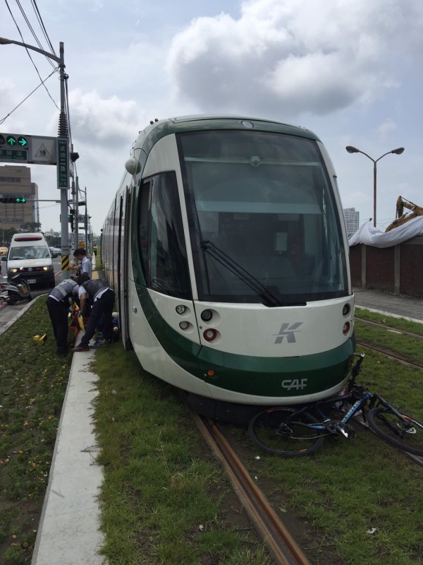 高雄輕軌列車今日行經台肥公司路口時，雨一名騎單車的老翁發生擦撞，腳踏車卡在列車下，所姓老翁只受輕傷。（警方提供）