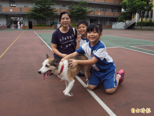 西門國小4年8班羅宥騏（中）和3年3班的妹妹羅淳姍（右），今天帶家中飼養的5歲狗兒圓圓到校和大家分享。（記者陳昀攝）