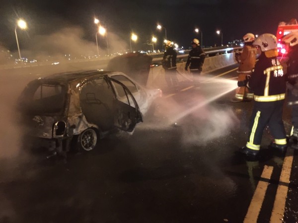 五楊高架北上車禍釀成火燒車，消防人員全力射水搶救。（記者李容萍翻攝）