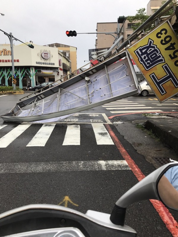 大型招牌狠狠地砸在摩托車頭前，所幸沒有造成任何人員傷亡。（網友提供）
