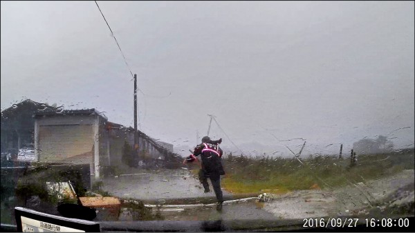 台西崙豐派出所警員冒著強風大雨跨越傾倒電線桿衝入民宅。（記者黃淑莉翻攝）