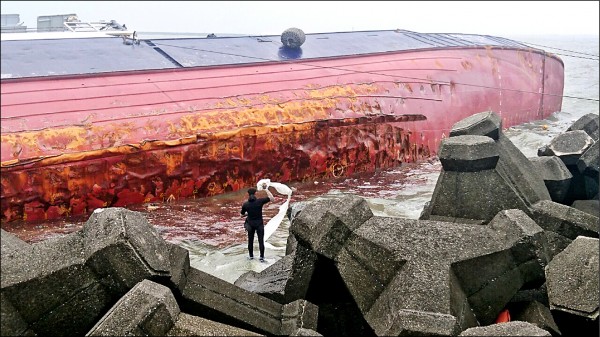 永興發一六八號漁船船邊發現油污，潛水員以除油棉吸除。（記者黃旭磊翻攝）