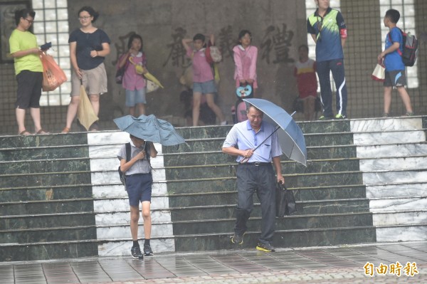 這次颱風來襲，很多地方卻只放半天假，讓民眾颱風天還需在外。（資料照，記者張忠義攝）