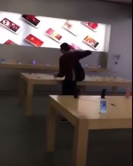 一位男子闖入蘋果門市，開始催毀iPhone。（圖擷取自YouTube）