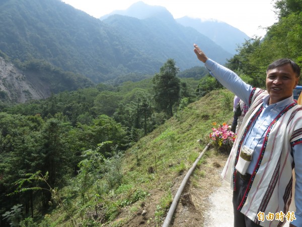 昔日居住沙里仙林道的布農族伍氏家族後代，指著山林說明過去全都是家族的石板屋，然因統治者關係被迫遷出，如今立牌能再現過去遷徙史，對家族意義重大。（記者劉濱銓攝）