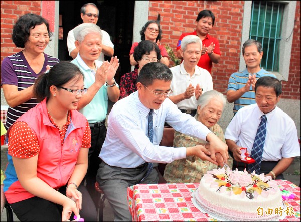 105歲的國慶寶寶王陳玉（前排左三）昨提前慶生，與鹿港鎮長黃振彥（前排左二）合切蛋糕。（記者湯世名攝）