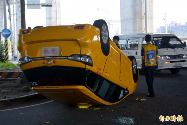 台中建國路和環中路口，今天上午發生計程車對撞，李姓運匠的計程車翻覆，所幸在民眾協助下，打破後車窗逃出車外。（記者陳建志攝）