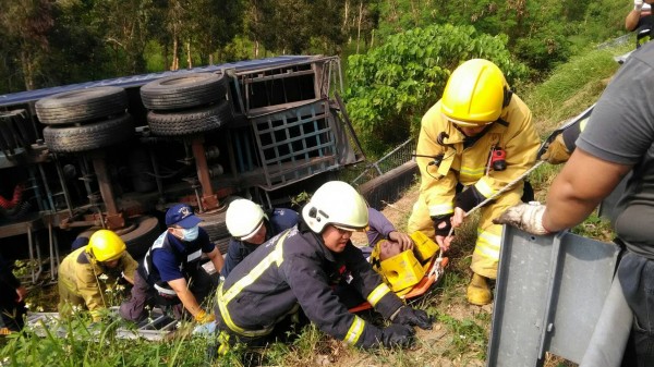 嘉義縣消防局人員將受傷的大貨櫃車駕駛送醫。（記者林宜樟翻攝）