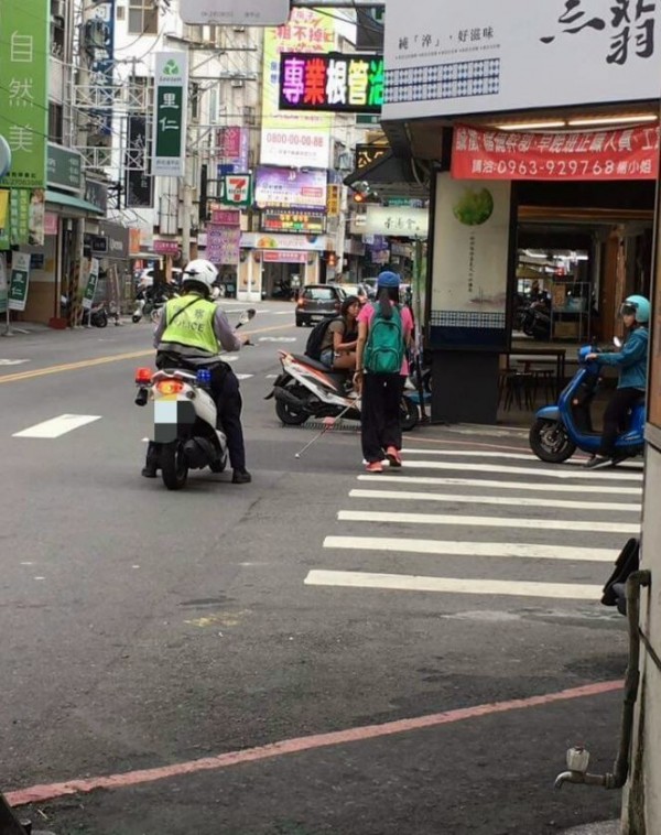 台中市西屯區一名警察在值勤時發現一名身障少女獨自一人過斑馬線，便一路在後默默護送她至站牌處。（圖擷自爆料公社）