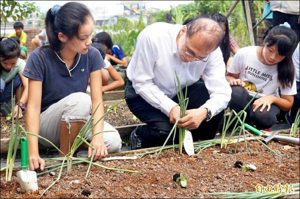 林全（中）與深溝國小學童一起種蔥。（記者林敬倫攝）