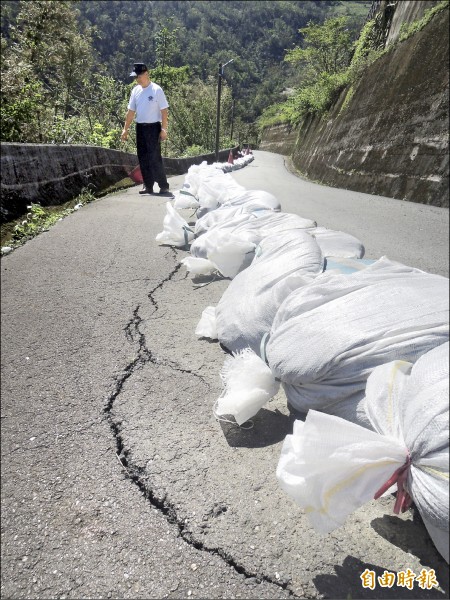 部落聯外山路路面龜裂，暫時用沙包阻隔。（記者江志雄攝）