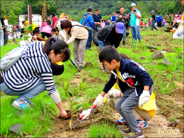 水公司為興建物料倉庫，將暖暖水源地約六千坪綠色隧道夷為平地，居民發起把樹種回去運動，大小朋友一起來種樹。（記者林欣漢攝）