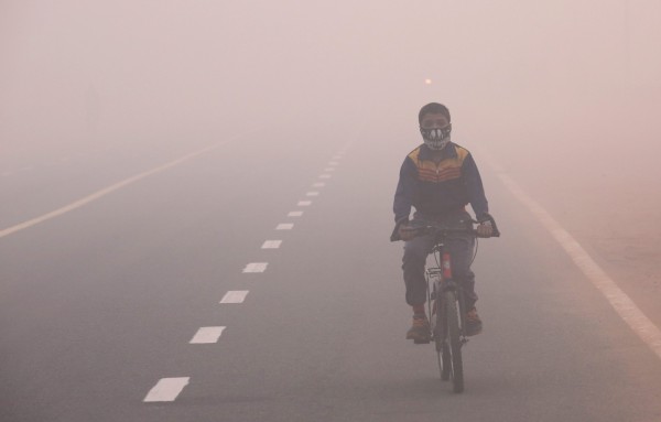 一名在新德里帶著口罩騎單車的孩童。（歐新社）