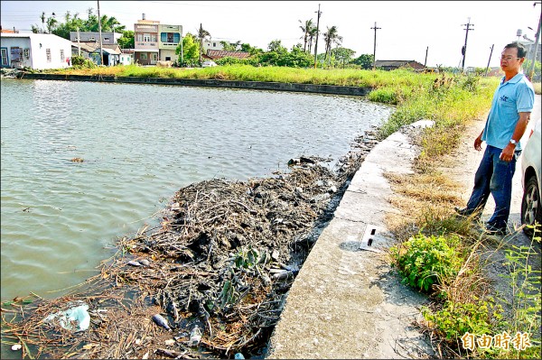 水林鄉一處魚塭遭傾倒廢土，引發放養魚苗的陳姓民眾不滿。（記者陳燦坤攝）