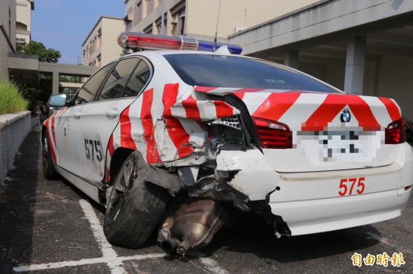 遭撞的BMW巡邏車左後方嚴重凹陷，不僅車輪歪掉，排氣箱也掉了下來。（記者邱芷柔攝）