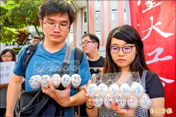 高教工會、政大、師大、陽明等校學生，不滿「學習型助理」氾濫，今年七月四日到教育部門口抗議，政治大學研究生高若想（右）最後在高教司專委王淑娟頭上將雞蛋捏爆。（資料照，記者吳柏軒攝）