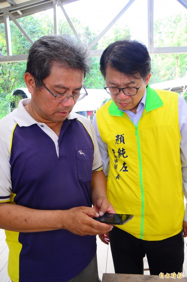 周俊吉（左）透過手機APP，就能掌握農地生產狀況。（記者吳俊鋒攝）