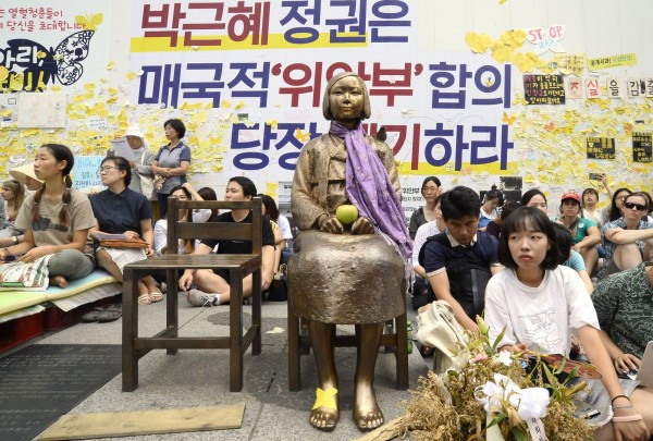 韓國女性家庭部及和解療癒基金會今（16日）表示，已有23名韓國慰安婦受害者領取1億韓元（合台幣約280萬元）的補償金。圖為日前韓國抗議人士聚集在象徵慰安婦的雕像旁，拒絕日本提供的補償金。（資料照，中央社）