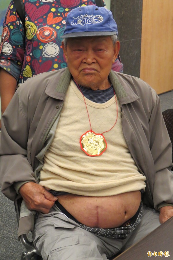 百歲人瑞于紀仲將衣服拉起，讓記者拍攝他腹部手術後的痕跡。（記者俞肇福攝）
