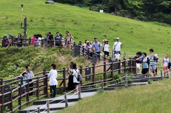 南韓濟州島因免簽政策吸引不少中國遊客到訪。圖為遊客走訪濟州島。（彭博）