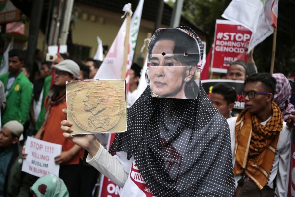 緬甸實際領袖翁山蘇姬未公開支持洛興雅族，更成為眾矢之的。圖為印尼穆斯林帶著翁山蘇姬面具於雅加達示威抗議。（美聯社）