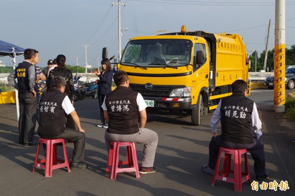 斗六市民代表坐在路中，不讓垃圾車進場。（記者林國賢攝）