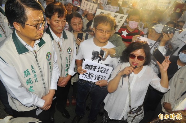 台南中會牧師机嘉勝（右2）與家長、信眾包圍台南市黨部，將陳情書遞給主委顏純左。（記者王捷攝）