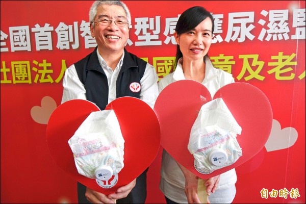 盧智成（左）研發的智慧型感應尿溼監測器，任何尿布都可以適用。（記者劉曉欣攝）