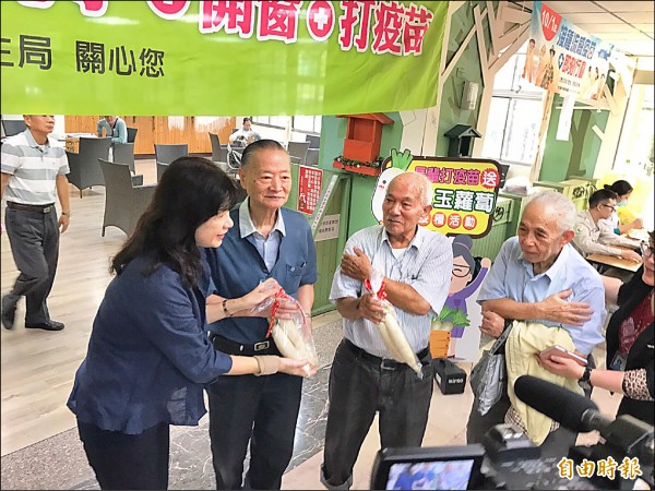 高市府副秘書長蔡柏英（左一）關心長輩接種流感疫苗情況，並贈送美濃白玉蘿蔔。（記者方志賢攝）