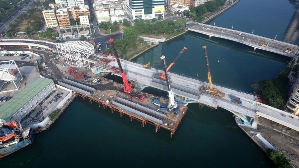 台鐵跨越高雄愛河舊鐵橋，在興建輕軌暫時拆除後，過了近3年，今天吊裝重返愛河。（高雄市捷運局提供）