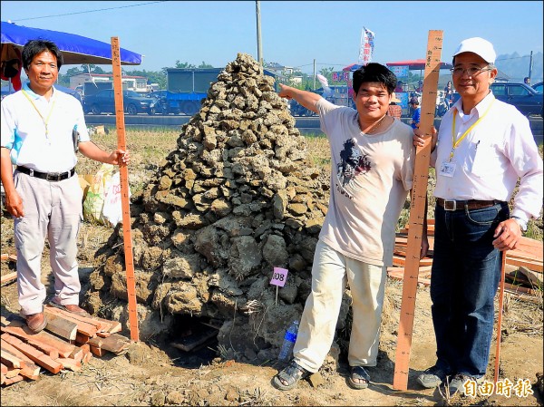 來自彰化芬園的溫啟文（右二）堆出高達180公分的土窯，順利連莊「天下第一大窯」。（記者佟振國攝）