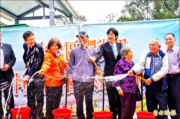 賴清德與在地居民一起打開水龍頭、灑出水柱，慶祝馬斗欄終於通水了。（記者林孟婷攝）