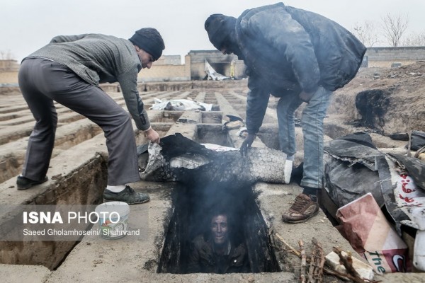 伊朗遊民為了避寒，竟睡在墳墓中。（圖取自ISNA）