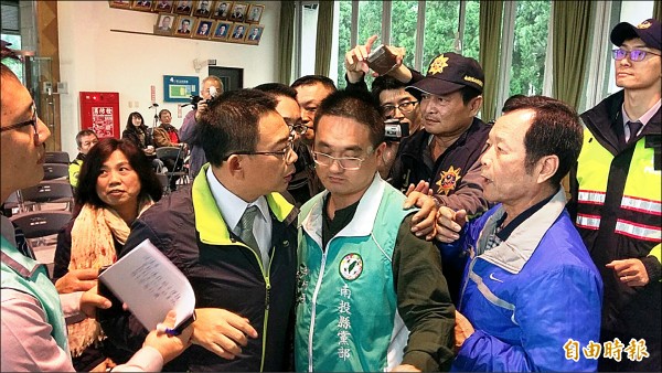 縣府召開孔雀園BOT案公聽會，民進黨縣議員林永鴻（前排，穿黑外套者）不滿議程排定，與在場的國民黨議員謝明謀（前排，穿藍外套者）發生推擠衝突。（記者劉濱銓攝）