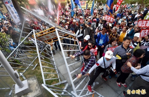 活動當天，成員推倒護欄企圖衝進座談會會場。（記者羅沛德攝）