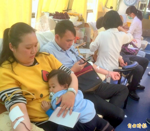 南投縣竹山鎮紫南宮舉辦「捐血作公益一送雞年錢母」活動，民眾參與踴躍，還有媽媽帶著小孩也挽袖捐血。（記者謝介裕攝）