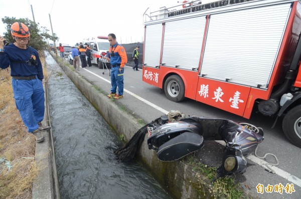 消防人員見余男騎乘的電動機車，研判可能跌落水圳裡，沿著水圳找人。（記者王秀亭攝）