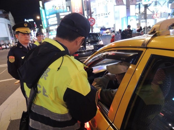 警方對計程車司機進行查核。（記者王冠仁翻攝）