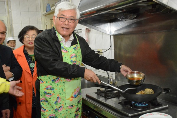 雲林縣長李進勇下廚，為寄養兒煮糖醋魚。（雲林家扶提供）