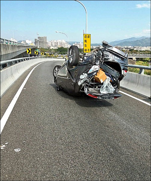 一輛轎車昨天中午疑似自撞，四輪朝天翻覆在台74線快速道路東平路匝道上，但駕駛卻不見蹤影。（記者陳建志翻攝）