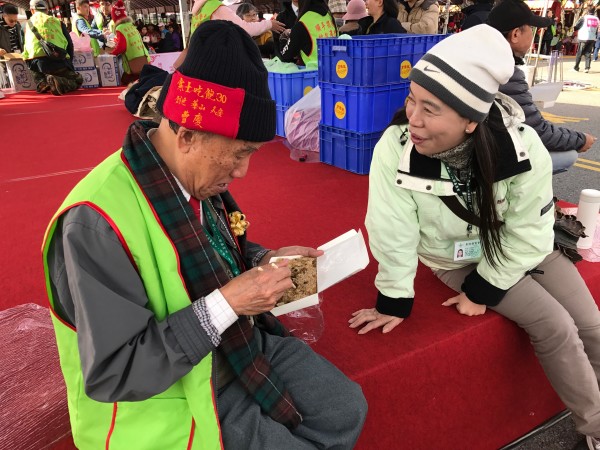 看到寒士尾牙圓滿結束，創世基金會董事長曹慶（左），下午二點才跟同仁一起吃冷掉的油飯。（記者陳炳宏攝）