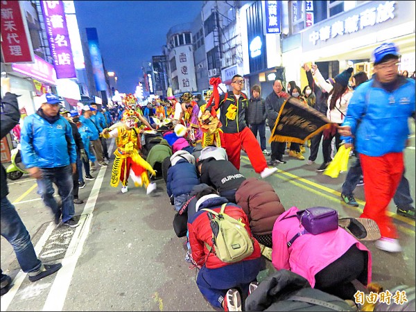 民眾也爭相跪地，接受家將消災解厄。（記者黃明堂攝）