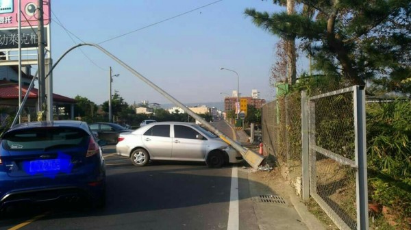 草屯鎮富林路發生車禍，轎車撞路燈，燈桿倒下壓車頂。（讀者林書演提供）