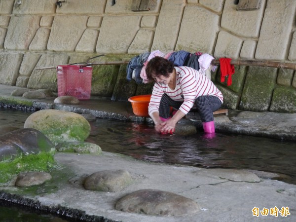 沙鹿區李姓婦女長年到南勢溪洗衣。（記者張軒哲攝）