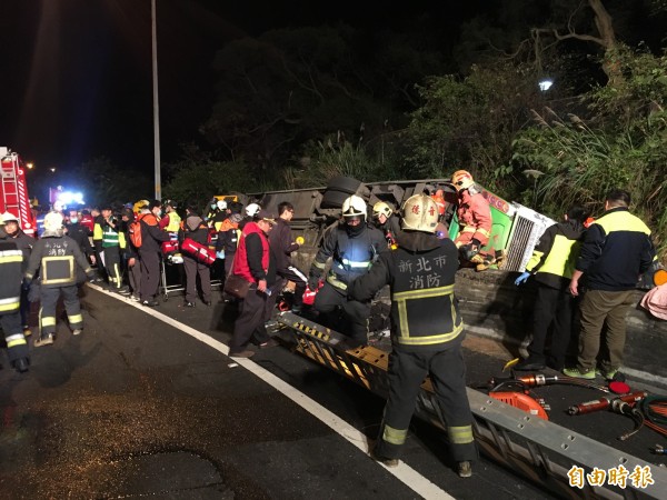 13日晚間國道五號接國道三號匝道發生遊覽車翻車事故，消防人員現場搶救。（記者姚岳宏攝）