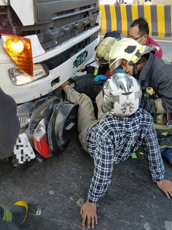 昭姓騎士與聯結車發生擦撞，連車帶人卡進車頭下。（記者王宣晴翻攝）