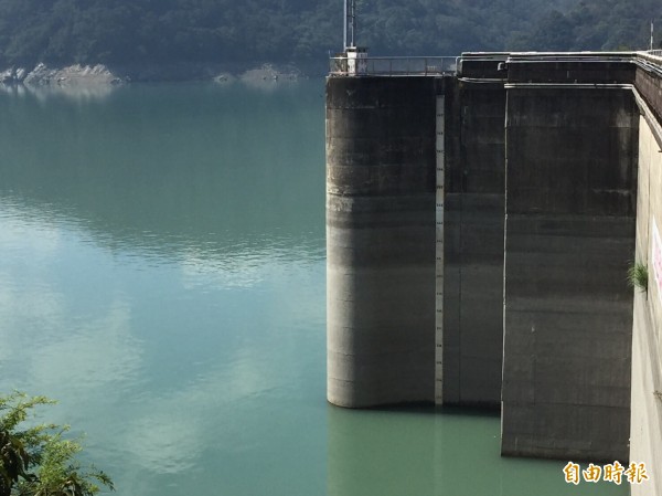 石門水庫苦等春雨報到，大壩水位直直往下探、露出一大截。（記者李容萍攝）