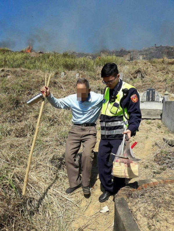 76歲陳姓老翁手持拐杖到墓園焚香祭拜先人，卻遇上雜草火警，警方獲報偕同消防隊前往救援，讓老翁免被火舌吞噬。（記者曾迺強翻攝）