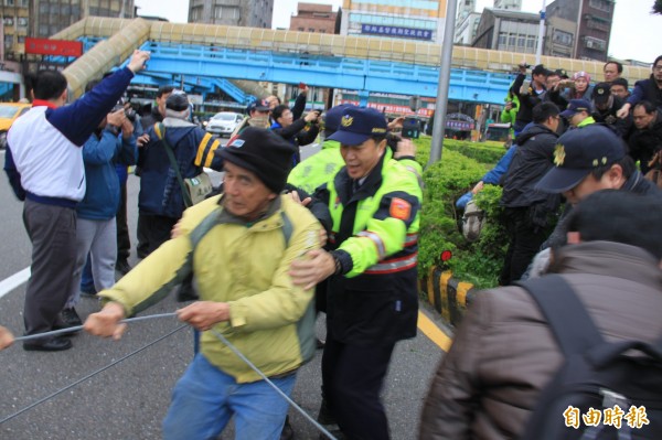 警方擔心民眾危險，將拉扯鋼纜的民眾拉回圓環中（記者吳昇儒攝）